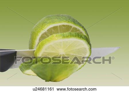Stock Image - A knife cutting a lime. Fotosearch
