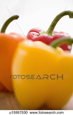 Stock Image - Close-up of yellow, orange and red peppers. Fotosearch