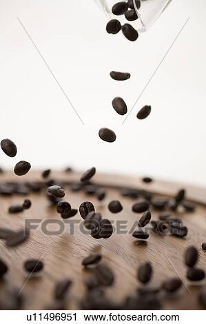 Coffee beans dropping onto wooden plate View Large Photo Image Stock Image - Coffee beans dropping onto wooden plate. Fotosearch