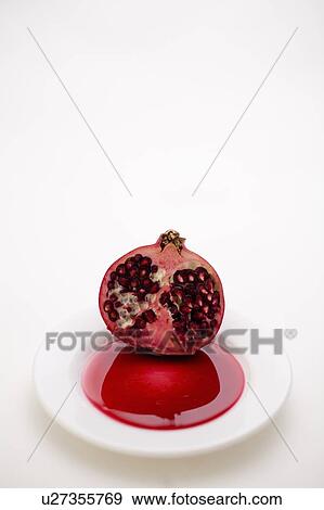 Stock Photo - Half a pomegranate on a white plate. Fotosearch