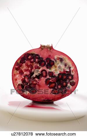 Stock Photo - Half a pomegranate on a white plate. Fotosearch