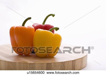 Yellow, orange and red peppers on butcher block cutting board in profile View Large Photo Image Stock Image - Yellow, orange and red peppers on butcher block cutting board in profile. Fotosearch