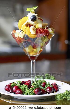 Stock Image - Festive fruit cocktail with mascarpone cheese in a martini glass garnished with cranberries. Fotosearch