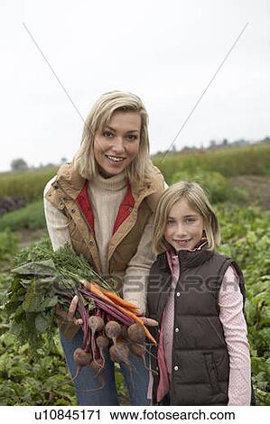 Stock Image - Mother and daughter at an organic farm with fresh vegetables, Ladner, British Columbia, Canada. Fotosearch