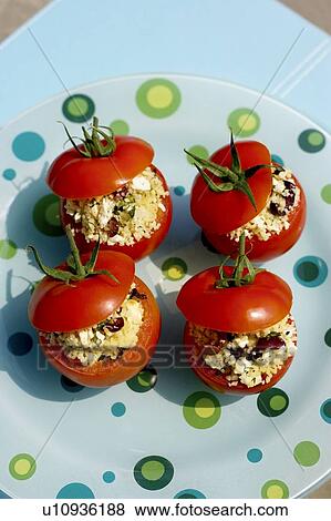Stock Photo - Stuffed tomato appetizer on polka-dotted turquoise plate, Canada, Ontario. Fotosearch