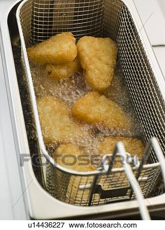 Stock Photo - Hash Browns being Deep Fried in Corn Oil. Fotosearch