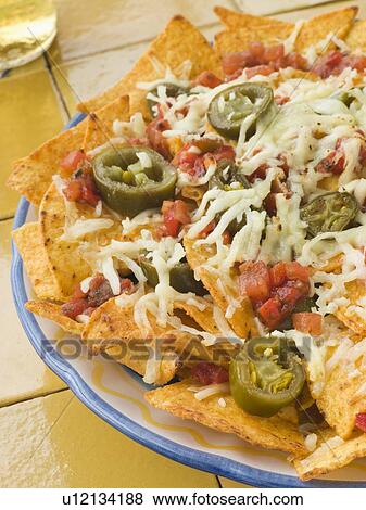 Stock Photo - Platter of Nachos with Salsa Jalapenos and Cheese. Fotosearch