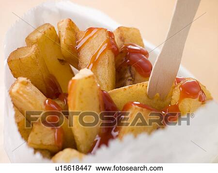Stock Photo - Chip Shop Chips in a Bag with a Wooden Fork and Tomato ketchup. Fotosearch