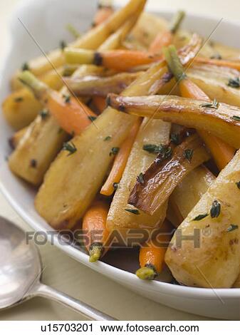 Stock Image - Parsnips and Baby Carrots Roasted in Thyme and Honey. Fotosearch
