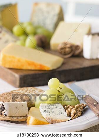 Stock Image - Plate of Cheese and Biscuits with a Cheese Board. Fotosearch