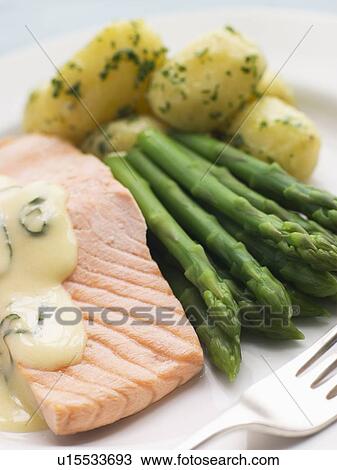Stock Image - Poached Salmon with Asparagus and Sorrel Sauce. Fotosearch