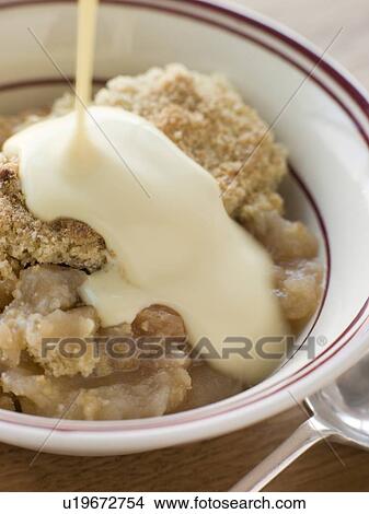 Picture - Bowl of Apple Crumble with Custard. Fotosearch