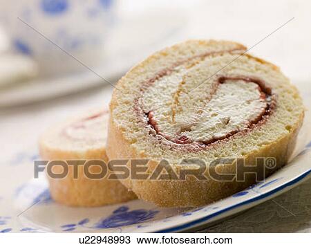 Stock Image - Cream and Strawberry Sponge Roll with Tea. Fotosearch