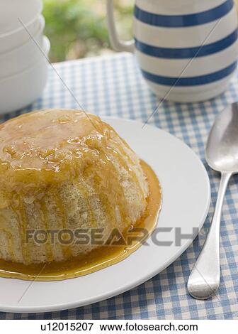 Stock Photo - Steamed Syrup Sponge with a jug of Custard. Fotosearch