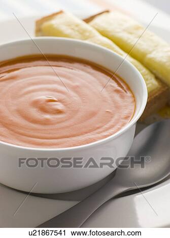 Stock Image - Bowl of Tomato Soup with Cheesy Toasted Soldiers. Fotosearch