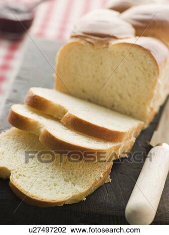 Stock Image - Brioche Loaf Sliced on a Chopping Board. Fotosearch