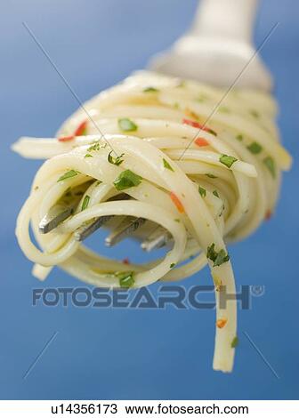 Stock Image - Chilli and Coriander Linguine twisted around a fork. Fotosearch