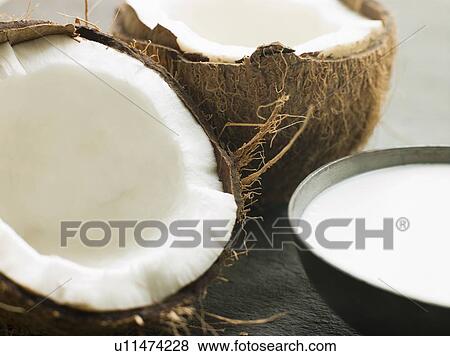 Stock Photo - Dish of Coconut Milk with a Split Fresh Coconut. Fotosearch