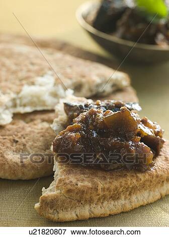 Stock Photo - Pot of Brinjal Chutney with Naan Bread. Fotosearch