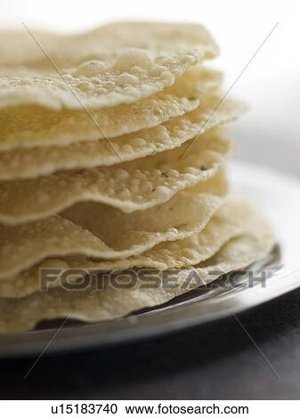 Stock Image - Stack of cooked Papadoms. Fotosearch