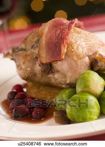 Stock Photograph - Roast Partridge Potato Cake Brussel Sprouts and Cranberry Jus. Fotosearch