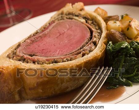 Stock Photography - Slice of Beef Wellington with Spinach and Saut ed Potatoes. Fotosearch