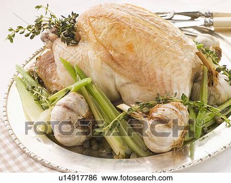 Stock Photograph - 40 Clove of Garlic Roasted Chicken with Baby Spring Vegetables. Fotosearch
