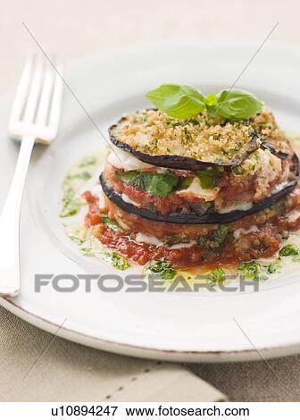 Stock Photo - Aubergine Parmigiana Tower with Herb Oil. Fotosearch