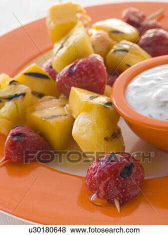 Stock Photo - Caramelised Fruit Brochette with Honey Creme Fraiche. Fotosearch