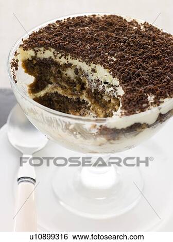 Stock Photograph - Individual Tiramisu with a spoon out. Fotosearch