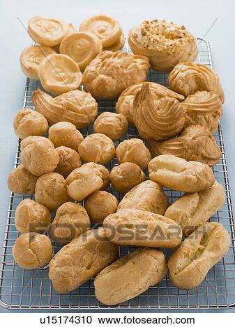 Stock Image - Selection of Choux Pastry Buns on a Cooling Rack. Fotosearch