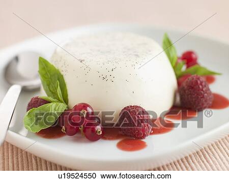 Stock Image - Vanilla Panna cotta with Raspberries Redcurrants and Coulis. Fotosearch