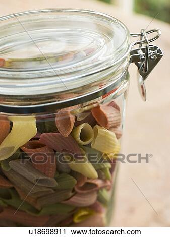 Stock Image - Jar of multi-coloured pasta. Fotosearch
