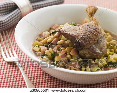 Stock Image - Confit Duck Leg with Flageolet Beans and Bacon. Fotosearch