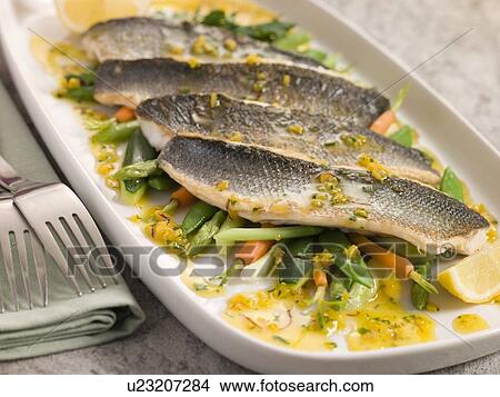 Fillets of Sea bass with Baby Vegetables and Saffron Butter View Large Photo Image Picture - Fillets of Sea bass with Baby Vegetables and Saffron Butter. Fotosearch
