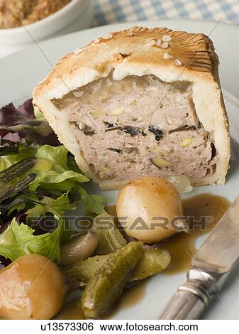 Stock Photograph - Pork Black Truffle and Pistachio Pie with Glazed Button Onions and Cornichons. Fotosearch