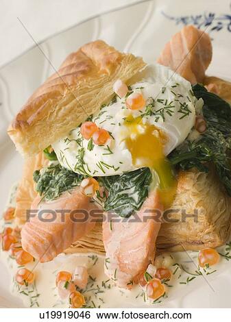 Stock Photograph - Seared Salmon Spinach and a Poached Egg in a Vol au Vent Case with a Dill and Keta Caviar Sauce. Fotosearch