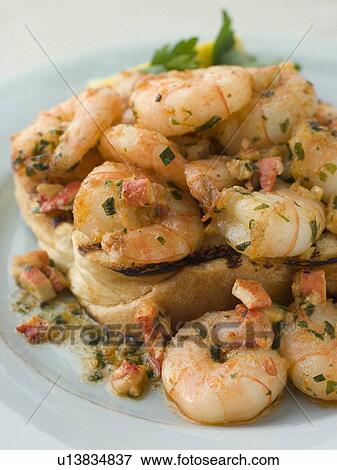 Stock Photo - Toasted Brioche topped with Prawns cooked In Lobster Garlic Butter. Fotosearch