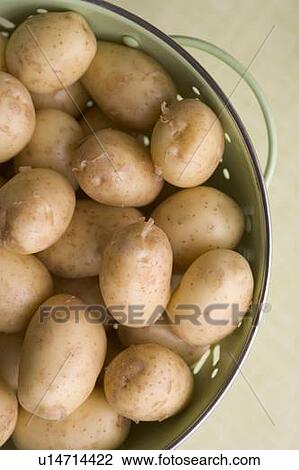 Stock Image - New potoes in collander. Fotosearch