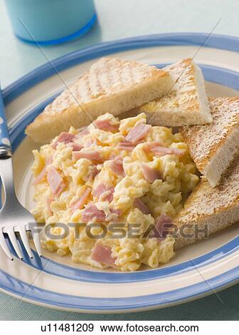 Stock Photo - Cheesy Scrambled Egg with Ham and Toasted Triangles. Fotosearch