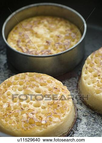Stock Image - Cooking Crumpets in a Frying Pan. Fotosearch