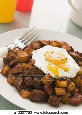 Corned Beef Hash with a Broken Fried Egg and Black Pepper View Large Photo Image Stock Image - Corned Beef Hash with a Broken Fried Egg and Black Pepper. Fotosearch