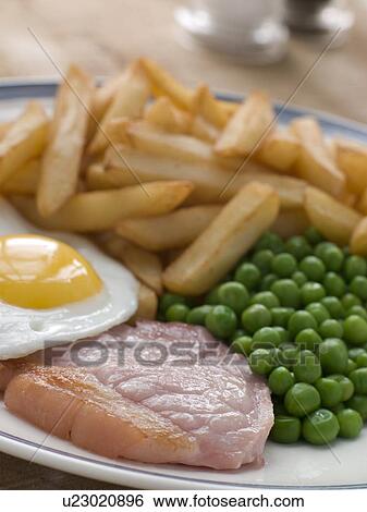 Stock Photograph - Gammon Steak Fried Egg Peas and Chips. Fotosearch