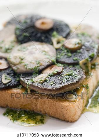 Stock Image - Garlic Field Mushrooms on Toast with Parsley Butter. Fotosearch