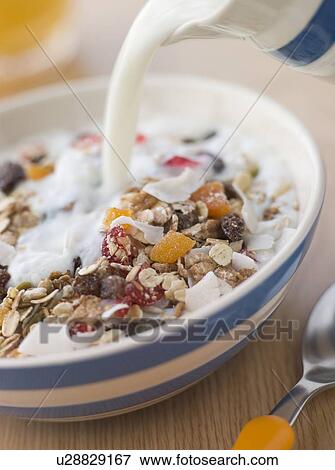 Stock Photo - Pouring Milk over a Bowl of Museli. Fotosearch