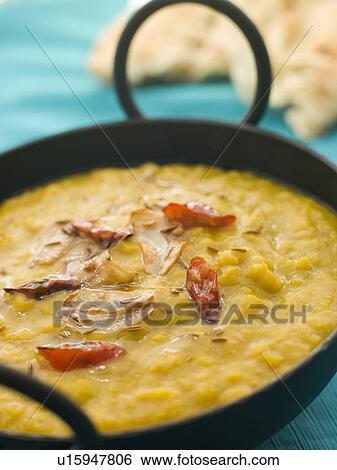 Stock Photograph - Karai Dish of Tarka Dhal with Naan Bread. Fotosearch