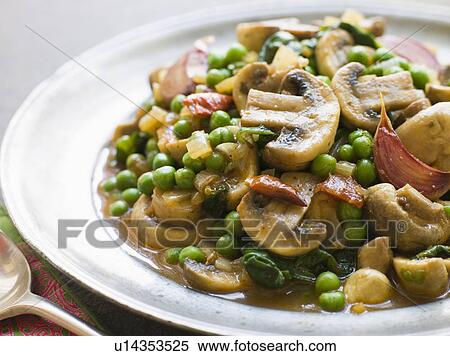 Stock Photography - Mushroom and Pea Curry with Roasted Garlic on a Pewter Plate. Fotosearch