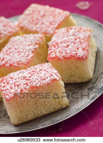 Stock Image - Pewter Plate with Coconut Cardamom and jam Sponges. Fotosearch