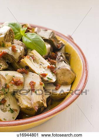 Stock Image - Marinated Baby Artichoke Salad with Sun Dried Tomatoes. Fotosearch