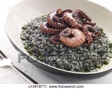 Stock Image - Risotto Nero with Fried Octopus and Pesto Dressing. Fotosearch